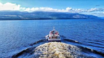 A boat on a large body of water with mountains in the background.