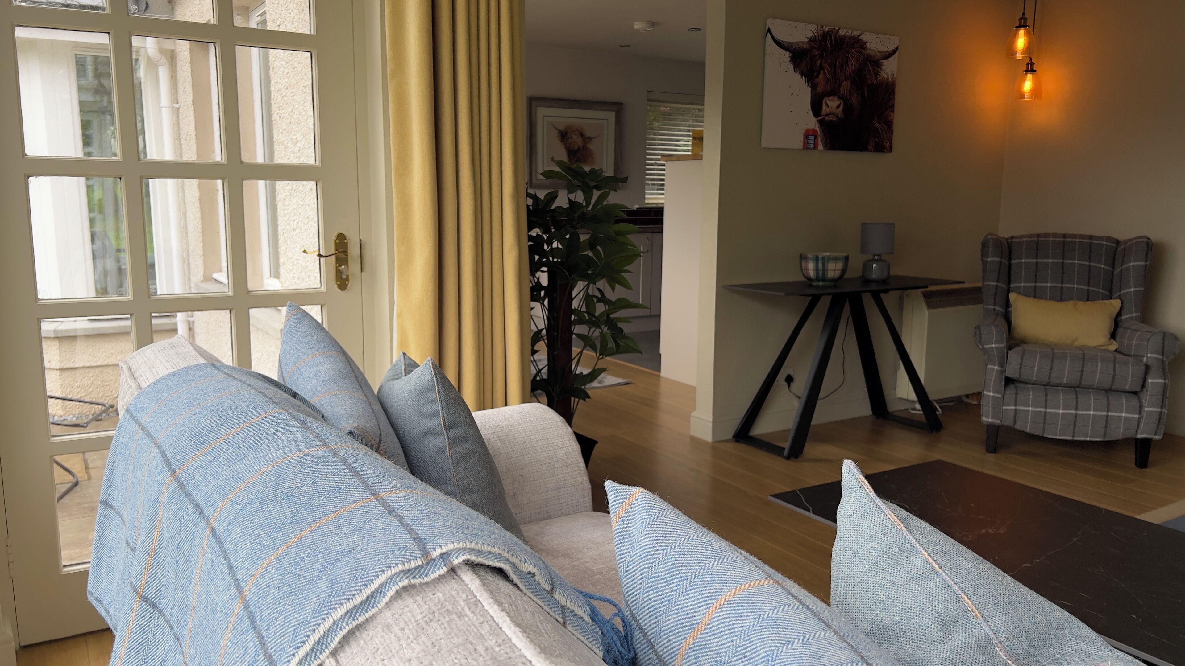 A living room with a sofa, armchairs, a coffee table, and a dining table.