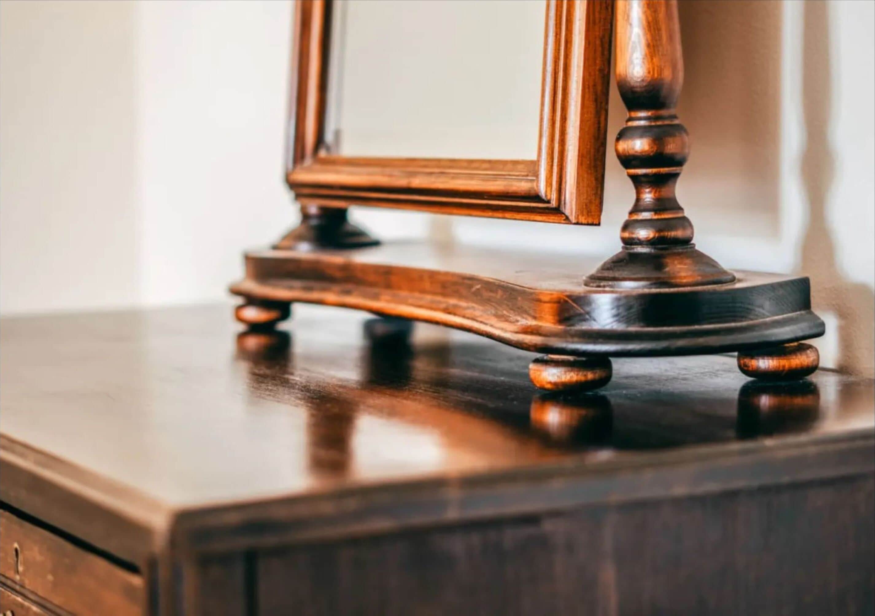 Een houten dressoir met spiegel en decoratieve onderkant.