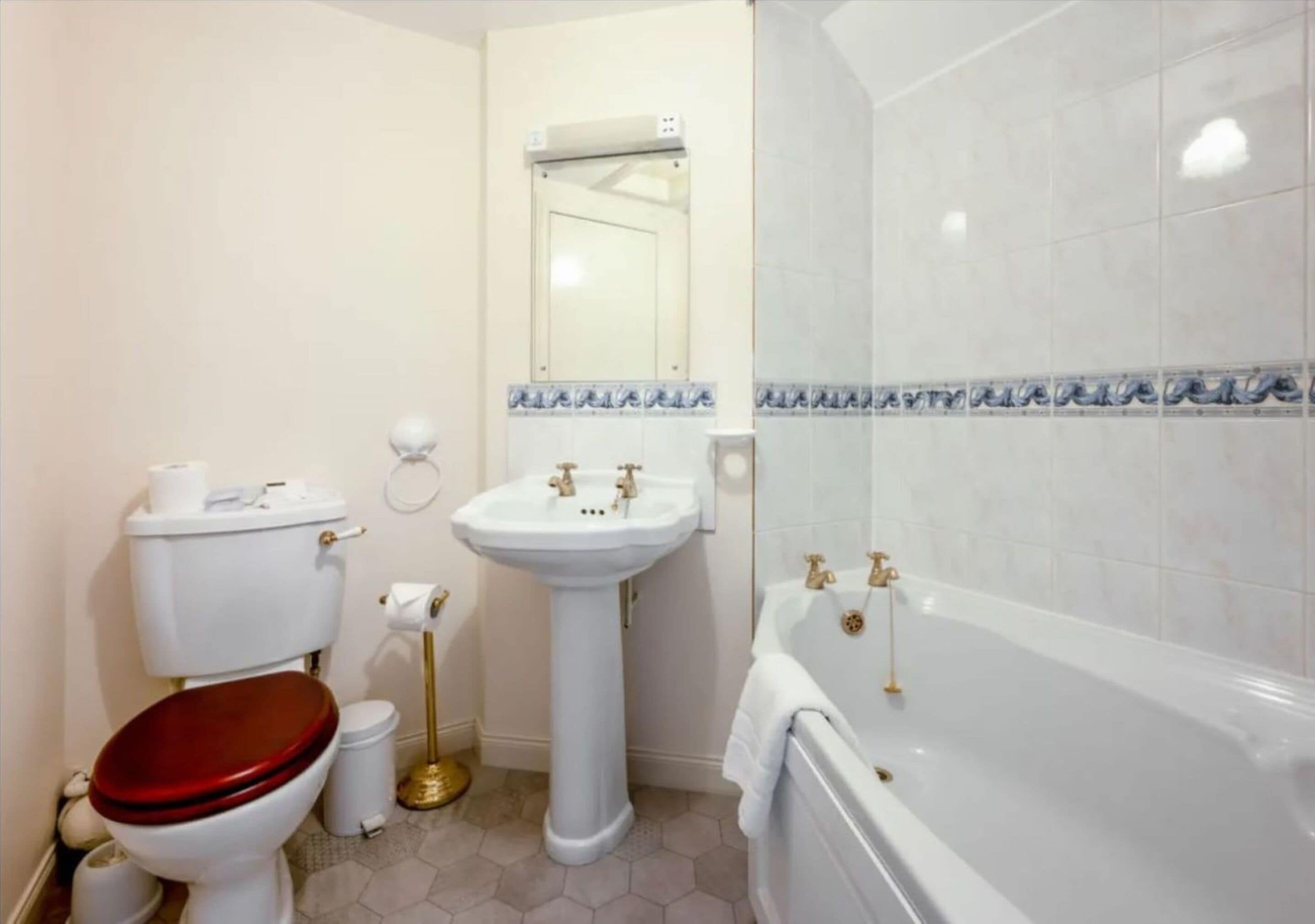 A bathroom with a toilet, sink, and bathtub.