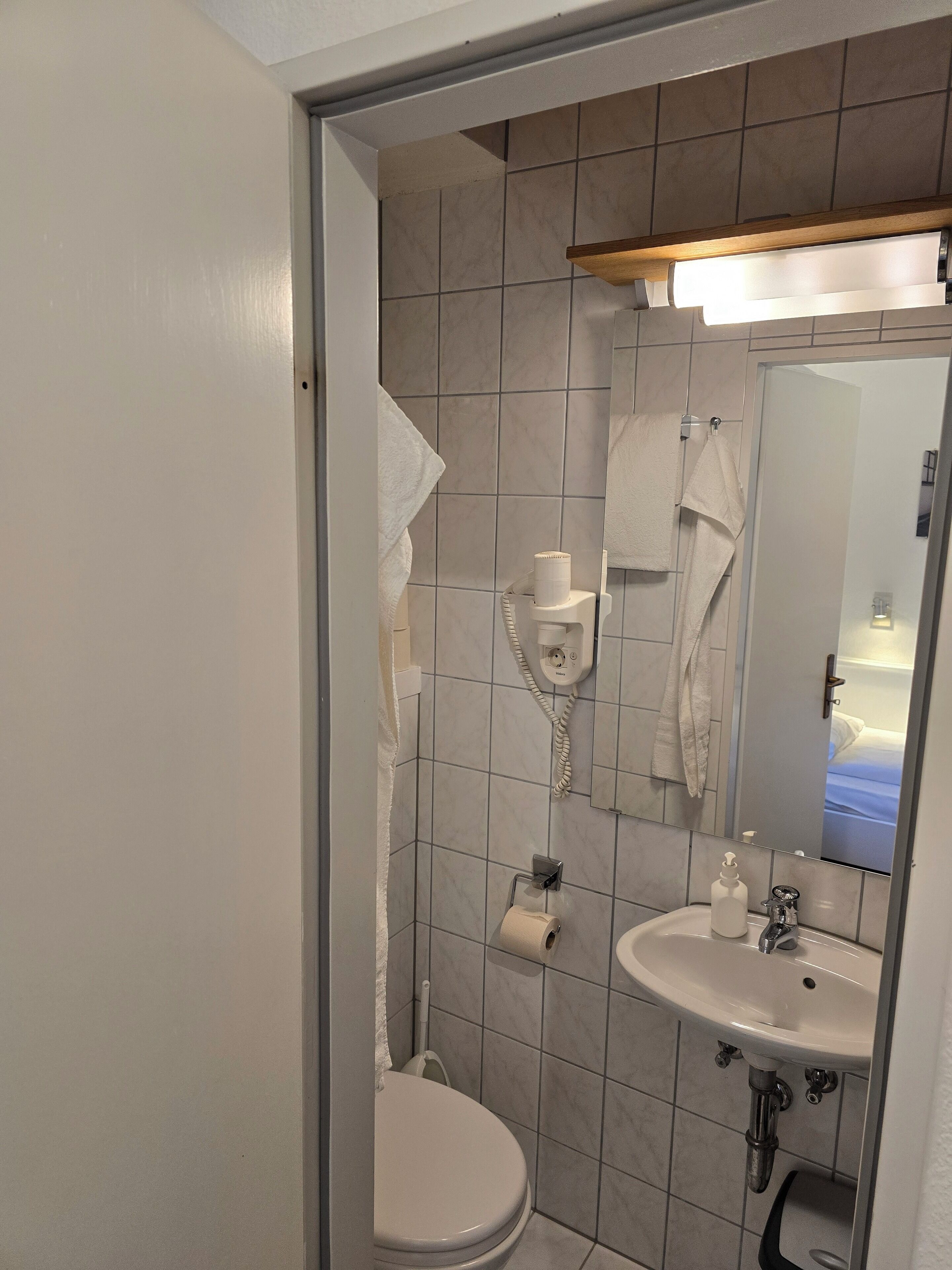 Un baño con inodoro, lavabo y espejo.