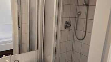 A modern bathroom with a shower, a sink, and a mirror.