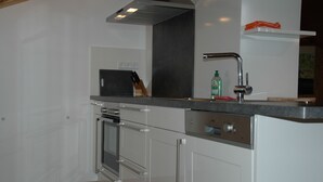 A modern kitchen with stainless steel appliances, a built-in oven, and a sink with a faucet. - Pension Haus Diefenbach (Heimbach)