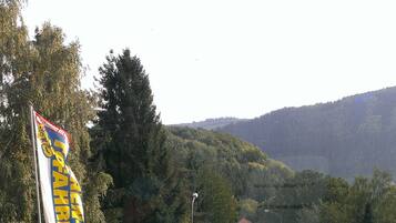 Une vue sur un paysage montagneux, visible à travers une fenêtre, avec un panneau indicateur en arrière-plan.
