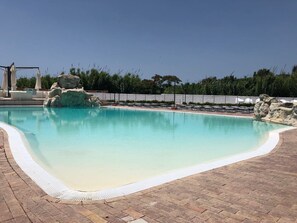 A swimming pool with a clear blue water, surrounded by a brick deck and a white safety border. - Villaggio Turistico Arco Delle Rose - Campsite (Agropoli)