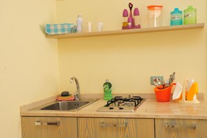 Een kookplaat, kookgerei, borden en bestek