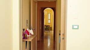 A hallway with an arched doorway leading to a dining area. - Camere Sulle Mura (Otranto)
