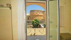 A room with a view of a historic stone wall and a potted plant. - Camere Sulle Mura (Otranto)