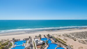 A resort with multiple swimming pools, a beach, and a clear view of the ocean. - Encanto Living 1202 -4BR by Kivoya (Puerto Peñasco)