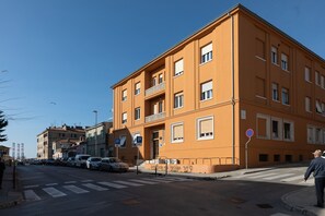 Un edificio de varios pisos con fachada plana, balcones y cielo despejado.
