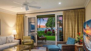 A living room with a glass door leading to a balcony with a view of the ocean and sunset. - SUMMER REDUCED! Villa 102-103 Stunning Ocean Views at Turtle Bay (Kahuku)