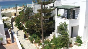 Un bâtiment blanc avec un chemin de pierre menant à une plage.