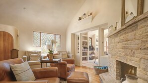 A cozy living room with leather sofas, a fireplace, and a bookshelf. - 3770 Stone's Throw ~ Walk to the Ocean and Town (Carmel)