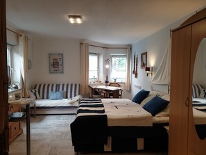 Ein gemütliches Schlafzimmer mit Bett, einer Couch, einem Schreibtisch und einem Essbereich.