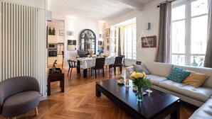 A spacious living room with a sofa, coffee table, and dining area. - Chez Aynur 2 bedroom apartment VRBO (Nice)