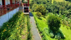 A two-story building with a balcony overlooking a lush green valley. - Lodge Paraiso Verde Manizales (Manizales)