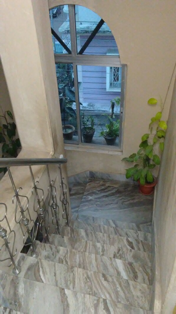 Una escalera de mármol con vistas a un jardín a través de una ventana.