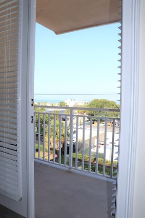 Enjoy the view from this balcony overlooking the parking area and surrounding buildings.
