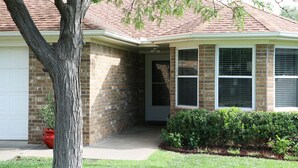 A house with a brick exterior, a red roof, and a front porch. - Clean, Light, Centrally Located, Quiet Neighborhood (Amarillo)