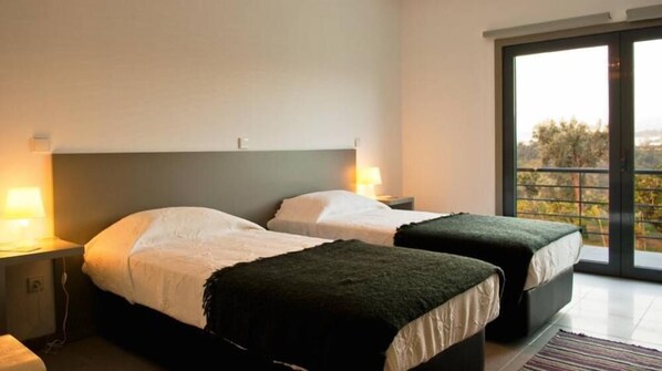 A bedroom with two beds, a large window, and a view of trees. - BE A PART OF THE RIVER, APART FROM IT ALL! (Alpendorada e Matos)