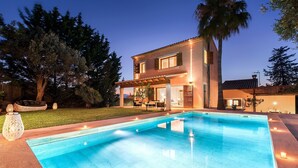 A two-story house with a swimming pool, outdoor seating area, and a well-maintained lawn. - Villa Elvissa by Balearic Villas (Alcúdia)