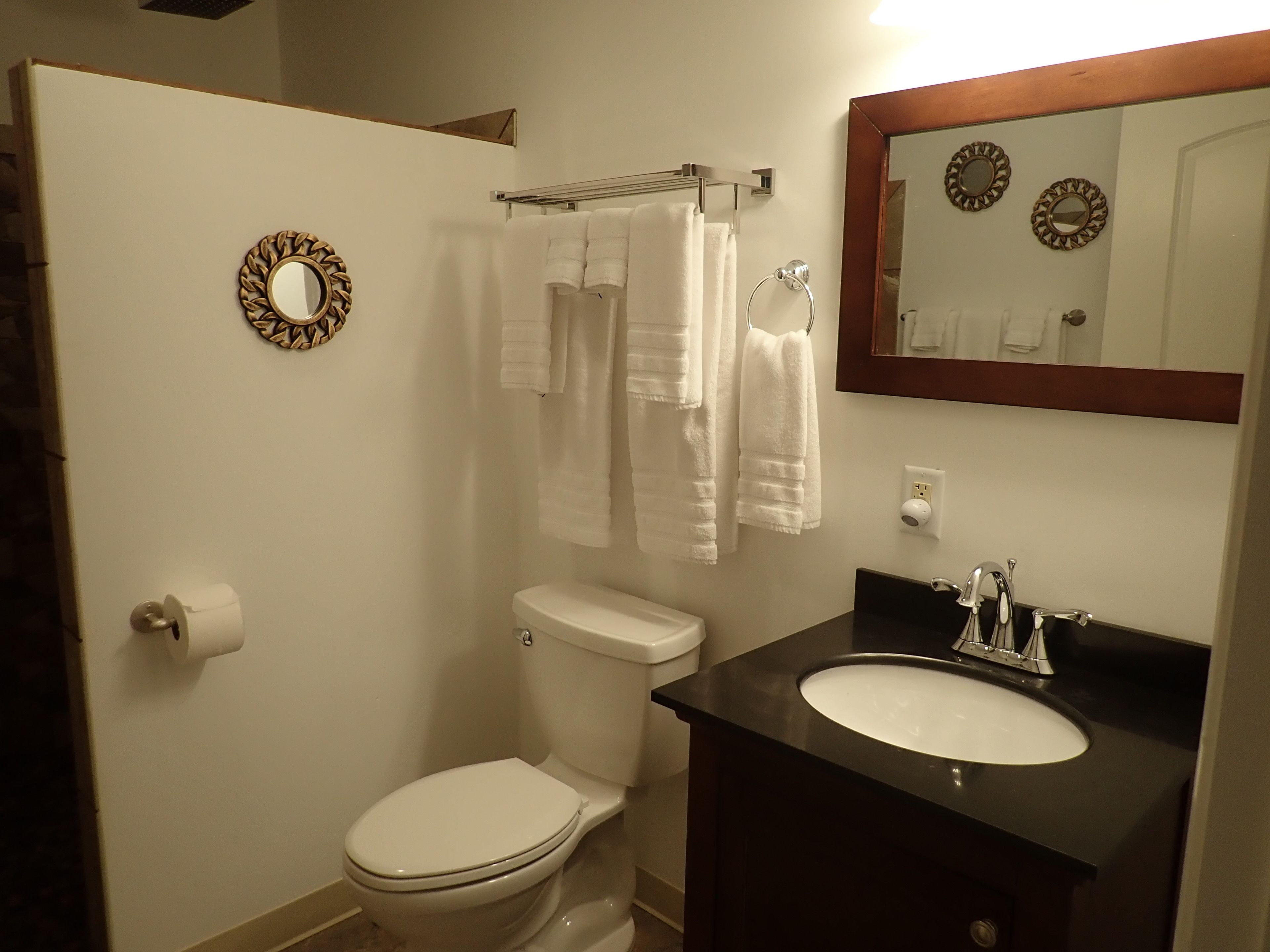 Une salle de bain équipée de toilettes, d’un lavabo et d’un porte-serviettes.