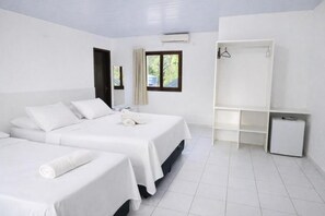 A hotel room with two beds, a wardrobe, a small trash bin, and a window with curtains. - Pousada Solar da Praia (Tamandaré)