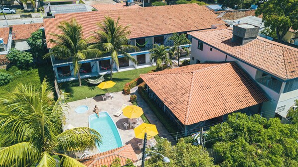 An aerial view of a hotel with multiple red-tiled roofs, a swimming pool, and outdoor seating areas. - Pousada Solar da Praia (Tamandaré)
