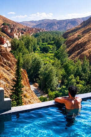 Une piscine offrant une vue sur un paysage montagneux et des champs en terrasses.