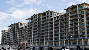 Un hotel de varios pisos con balcones, techo plano y cielo despejado.