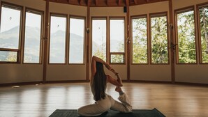 A spacious room with a high wooden ceiling and large windows offering a mountain view. - The Sentinel (Kaslo)