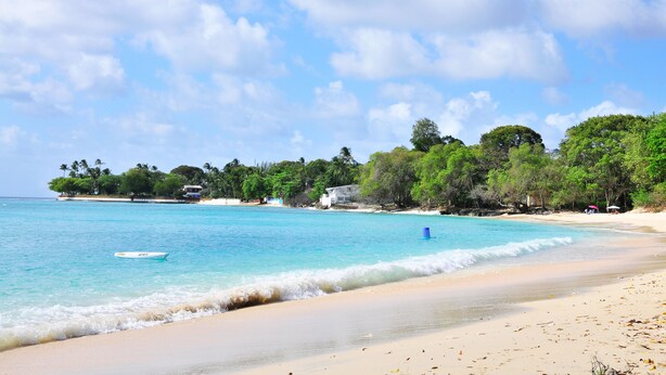 A beach with clear turquoise water, a boat, and a sandy shore. - ZenBreak - Seagaze Villa (Gibbes)