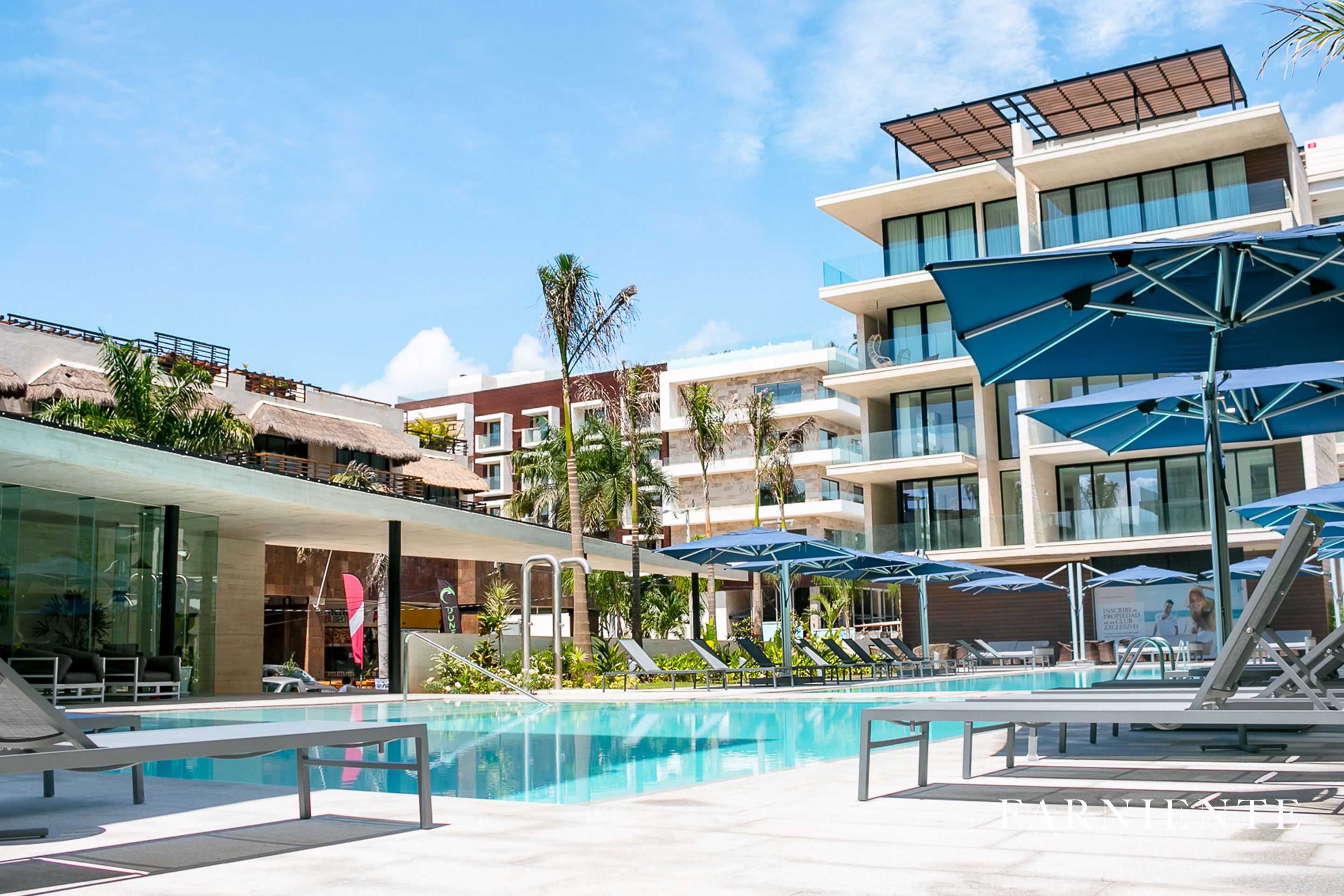 Een modern hotel met een zwembad, ligbedden en parasols.
