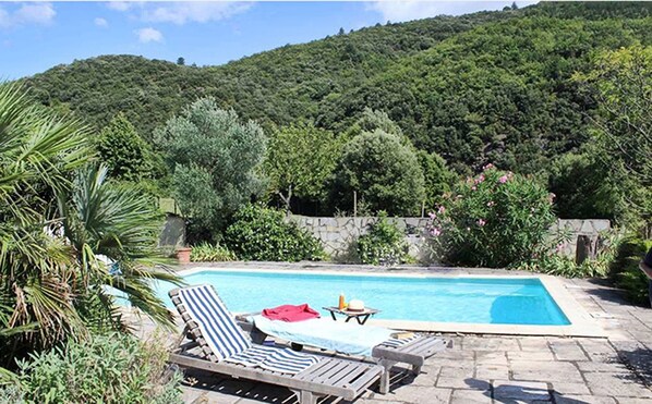 Una piscina al aire libre, tumbonas