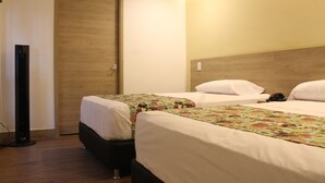 A hotel room with two beds, wooden headboard, and a wooden door. - Hotel Poma - Rosa (Medellín)