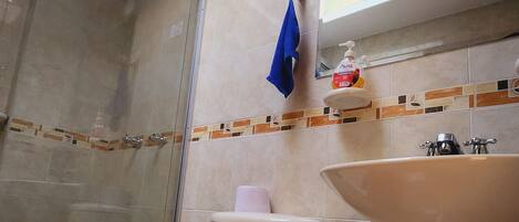 Ein Badezimmer mit Toilette, Waschbecken und Duschbereich.