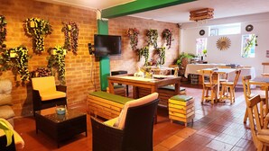 Un comedor acogedor y bien iluminado, con paredes de ladrillo, muebles de madera y plantas decorativas.