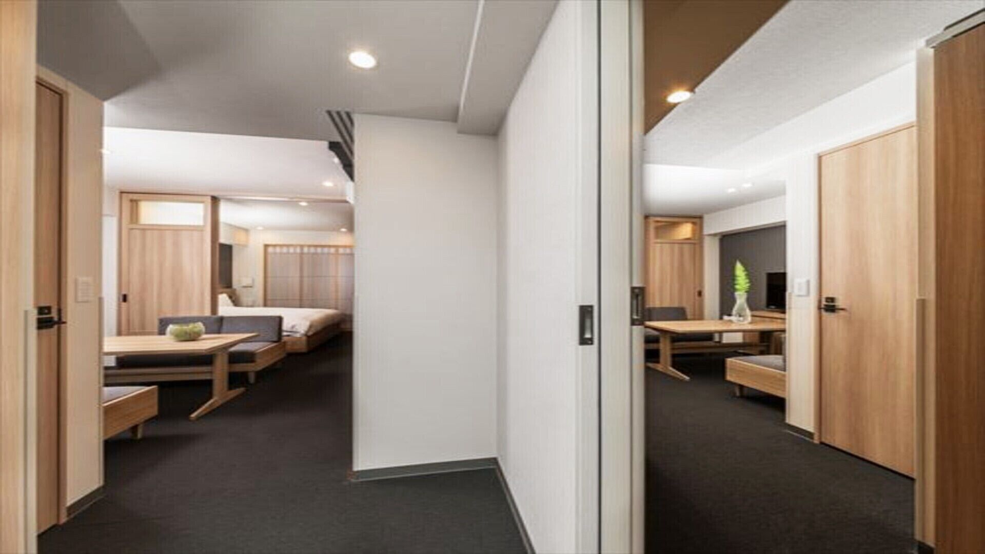 A modern hotel room with a bed, bedside table, and a small desk area.