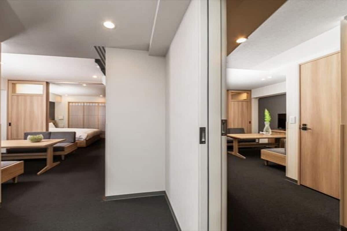 A modern hotel room with a bed, bedside table, and a small desk area.