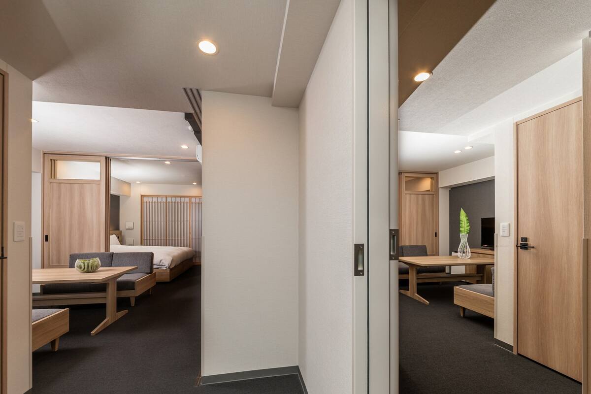A modern hotel room with a bed, a desk, and a seating area.