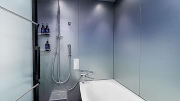 A modern bathroom with a walk-in shower, a bathtub, and a small step stool.