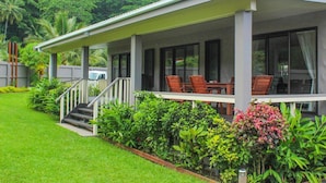 Ein modernes Haus mit einer Veranda und einem Essbereich, sowie einer Treppe zum Eingang.