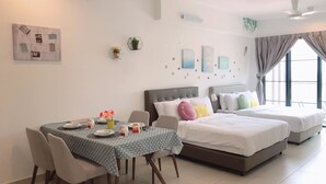 A modern hotel room with a dining area, a large bed with two pillows, and a small table with chairs. - ETM Midhill Private Studio Room (Genting Highlands)