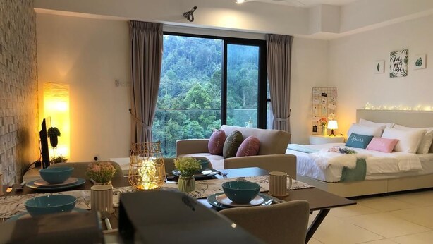 A modern living room with a sofa, dining table, and a large window with curtains. - ETM Midhill Genting Scenery Studio Room (Genting Highlands)