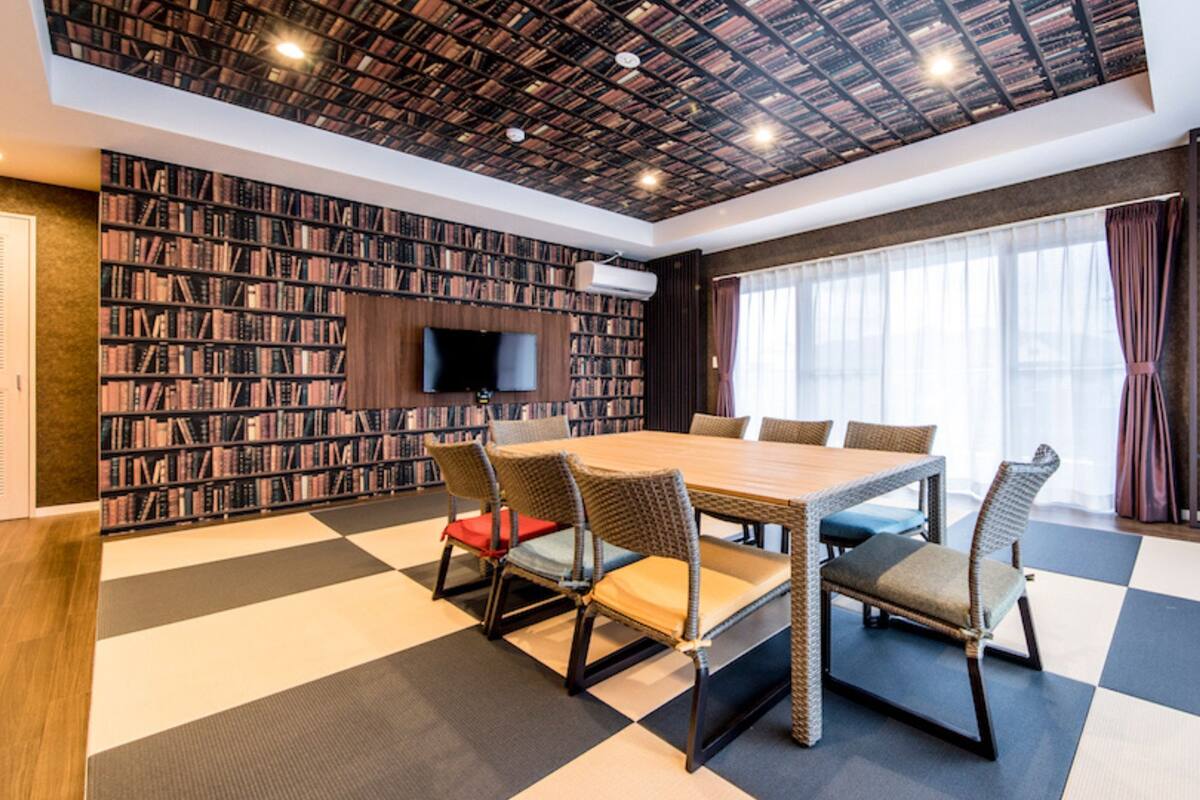 A modern library with a checkered floor, a wooden table, and bookshelves.