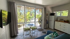 Ein kompakter Wohnbereich mit Küchenzeile, einem Essbereich mit Tisch und Stühlen sowie einer Couch.