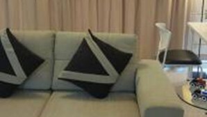 Una sala de estar con un sofá, una mesa de centro y una lámpara.