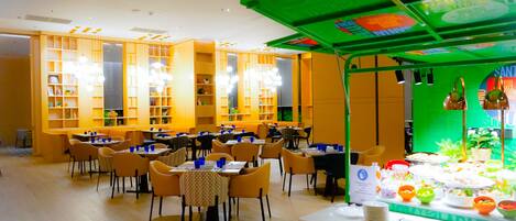 Un restaurant doté de nombreuses tables et chaises, d’un auvent vert et d’un présentoir à menus.