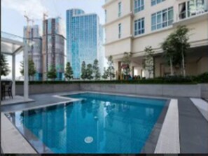 A swimming pool with a view of modern buildings in the background. - Bangsar Camelia Homestay KL (Kuala Lumpur)