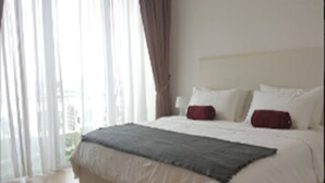A hotel room with a large bed, white bedding, and a view through sheer curtains. - Bangsar Camelia Homestay KL (Kuala Lumpur)